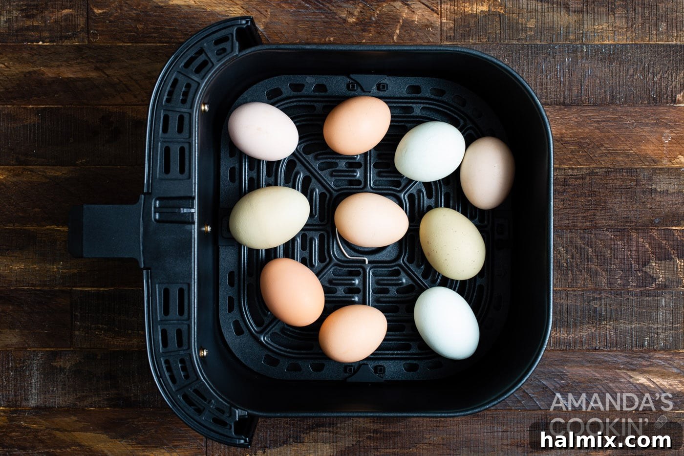 Eggs arranged neatly in an air fryer basket, ready for cooking