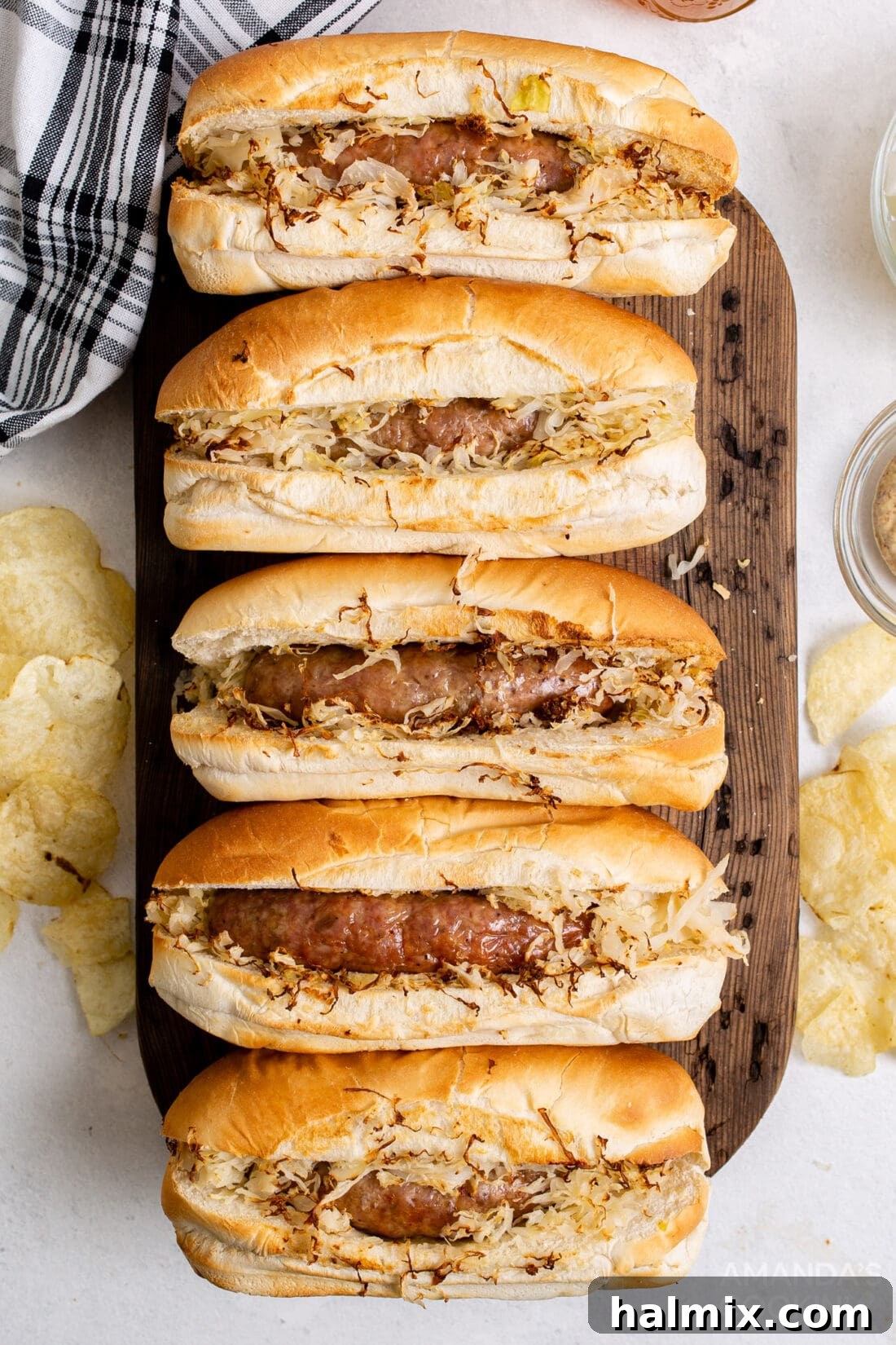 Perfect Air Fryer Bratwurst 2 air fryer bratwurst in buns with sauerkraut on cutting board