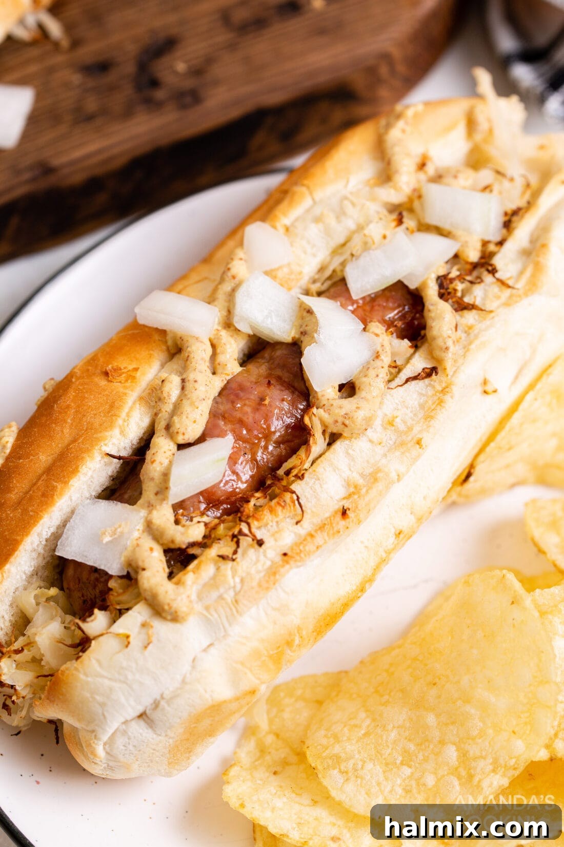 Perfect Air Fryer Bratwurst 9 air fryer bratwurst on a bun with sauerkraut, mustard and onion