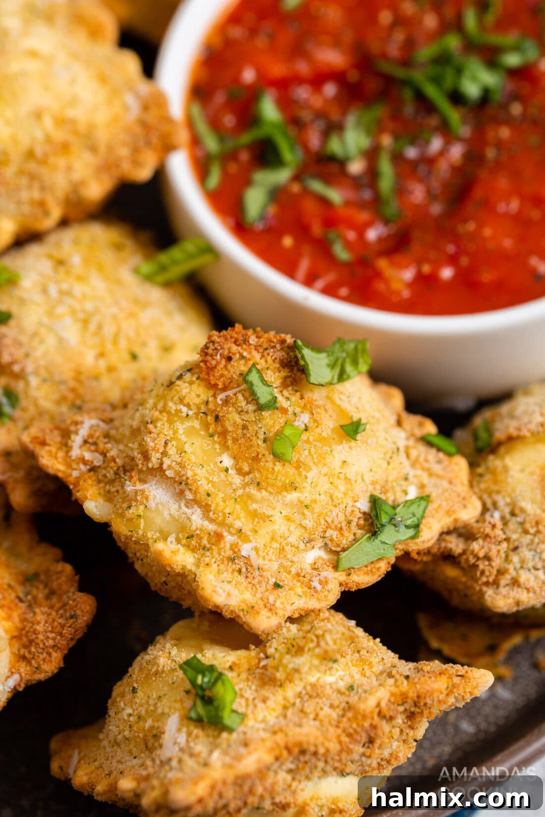 Crispy Golden Air Fryer Ravioli 3 A bowl of crispy air fryer ravioli served next to a small dish of marinara sauce, ready for dipping.