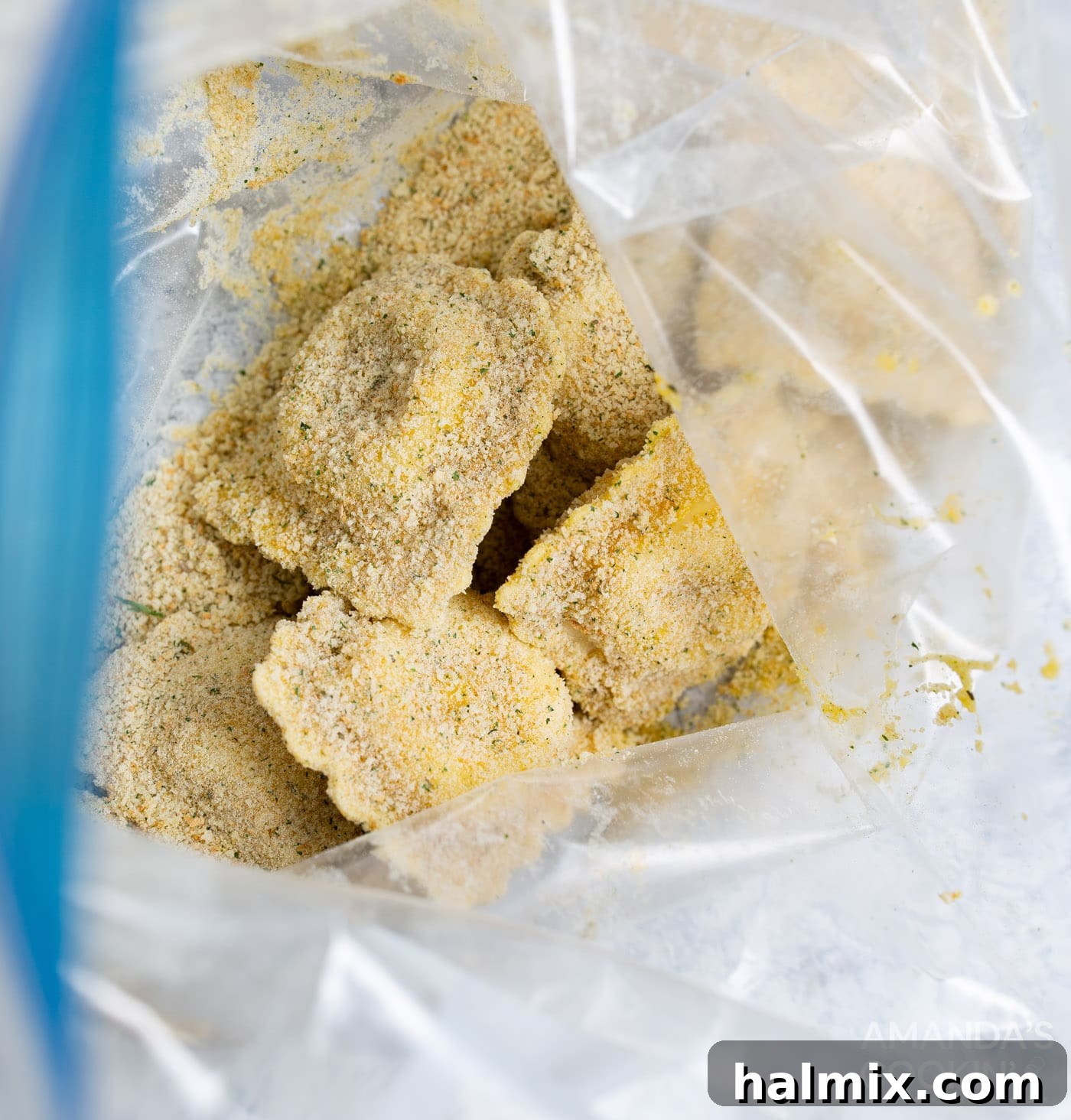 Ravioli coated in egg wash now being shaken in a Ziploc bag with Italian seasoned breadcrumbs.