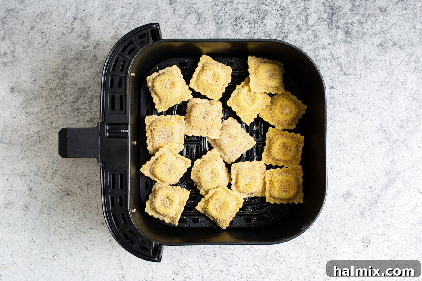Another view of the crispy air fryer ravioli inside the air fryer, nearly ready to serve.