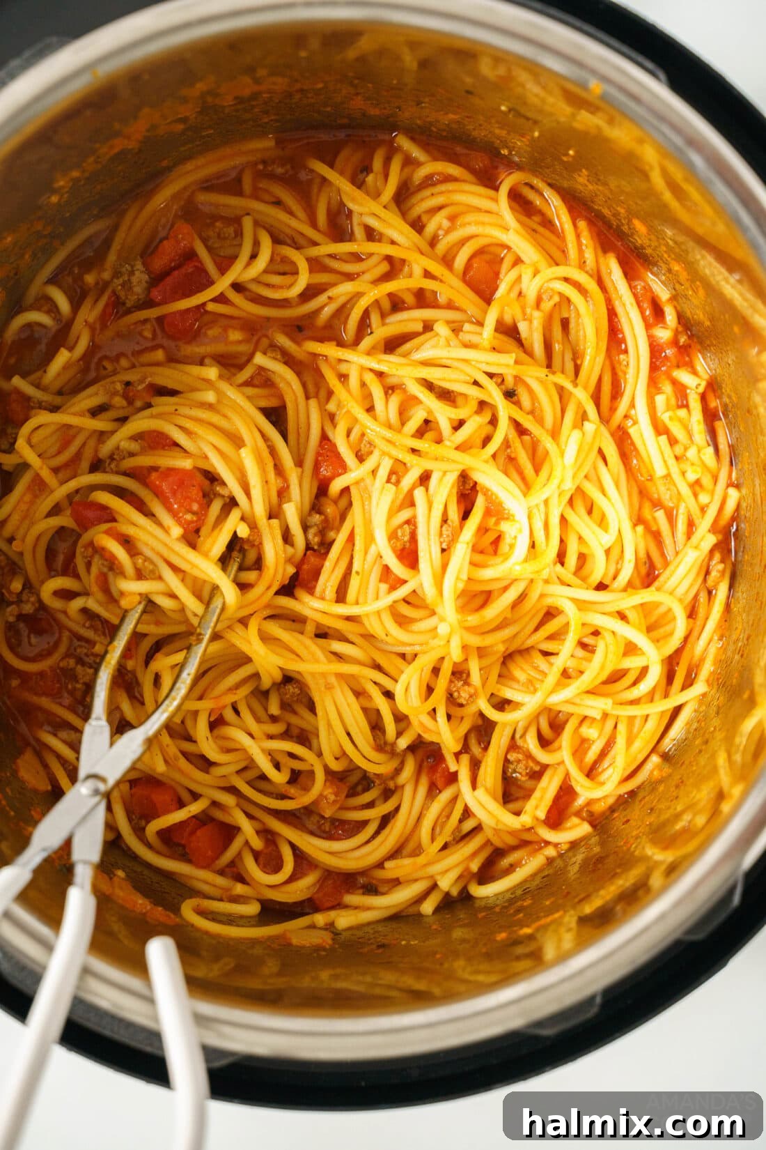 Effortless Instant Pot Spaghetti with Rich Meat Sauce 2 Overhead photo of a steaming plate of Instant Pot Spaghetti and Meat Sauce, garnished with fresh basil and Parmesan cheese