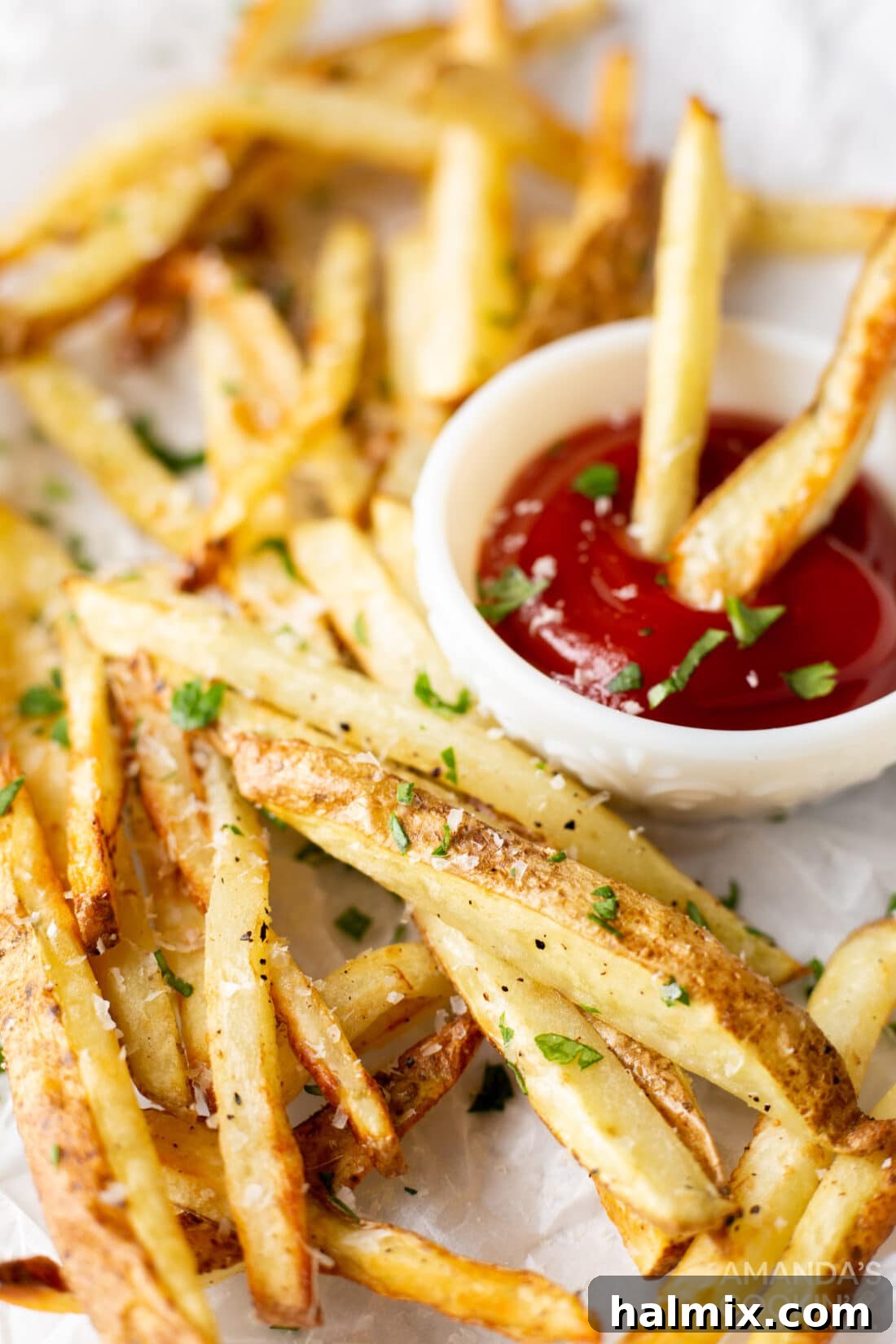 Crispy Golden Air Fryer Fries 9 A close-up of crispy air fryer French fries served on a white plate with a ramekin of ketchup, ready for dipping.