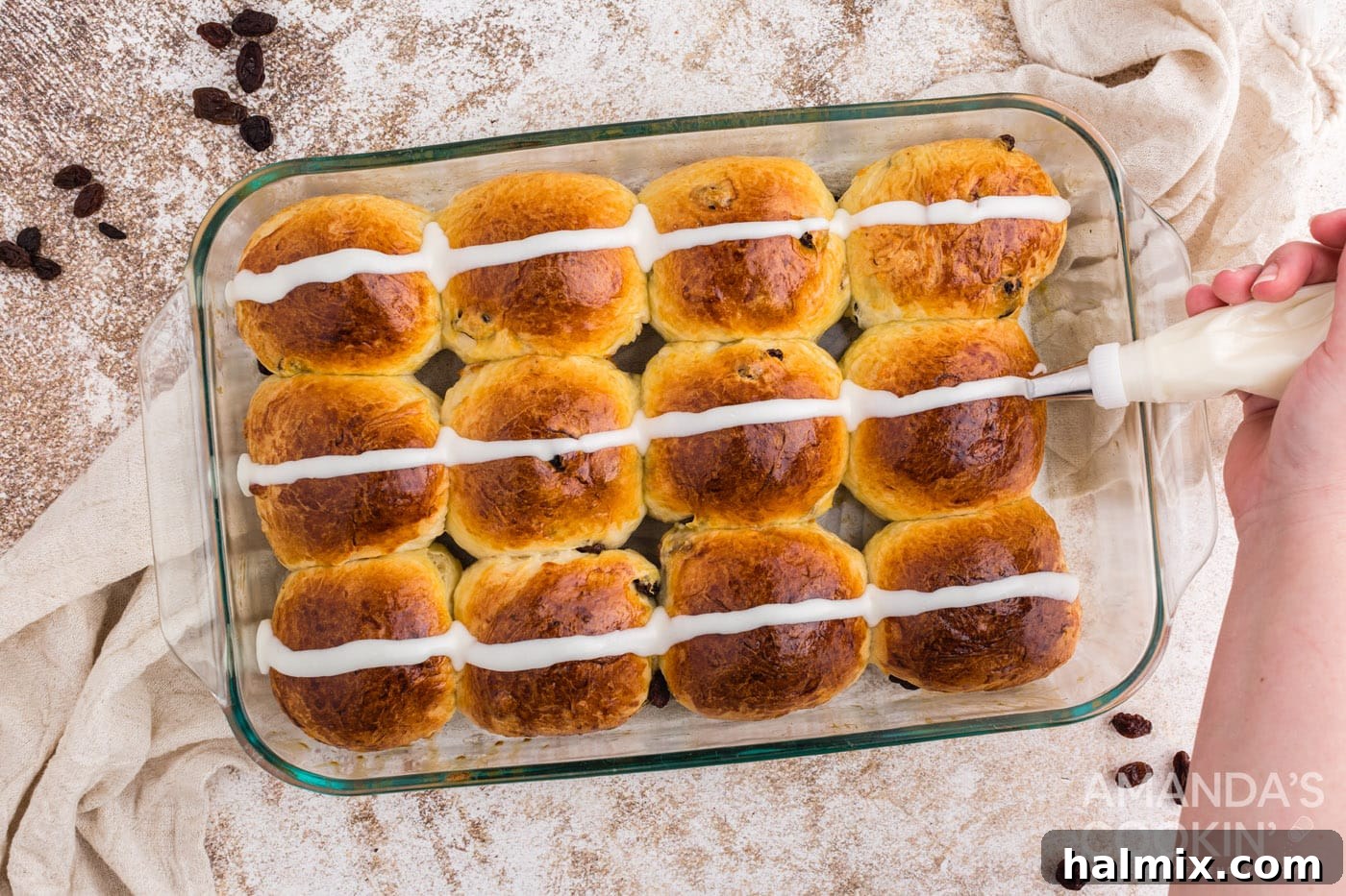 Spiced Easter Delights 17 Adding icing strips to baked buns in a pan to form crosses