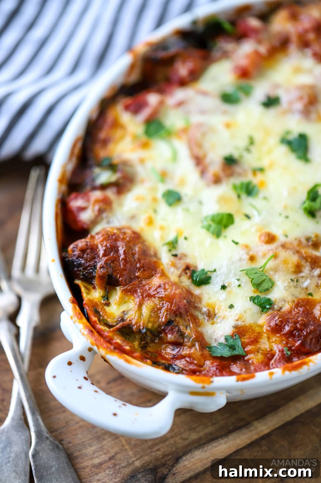 Close-up of a serving of Cheesy Ravioli Lasagna, showing melted cheese and layers, garnished with fresh basil.