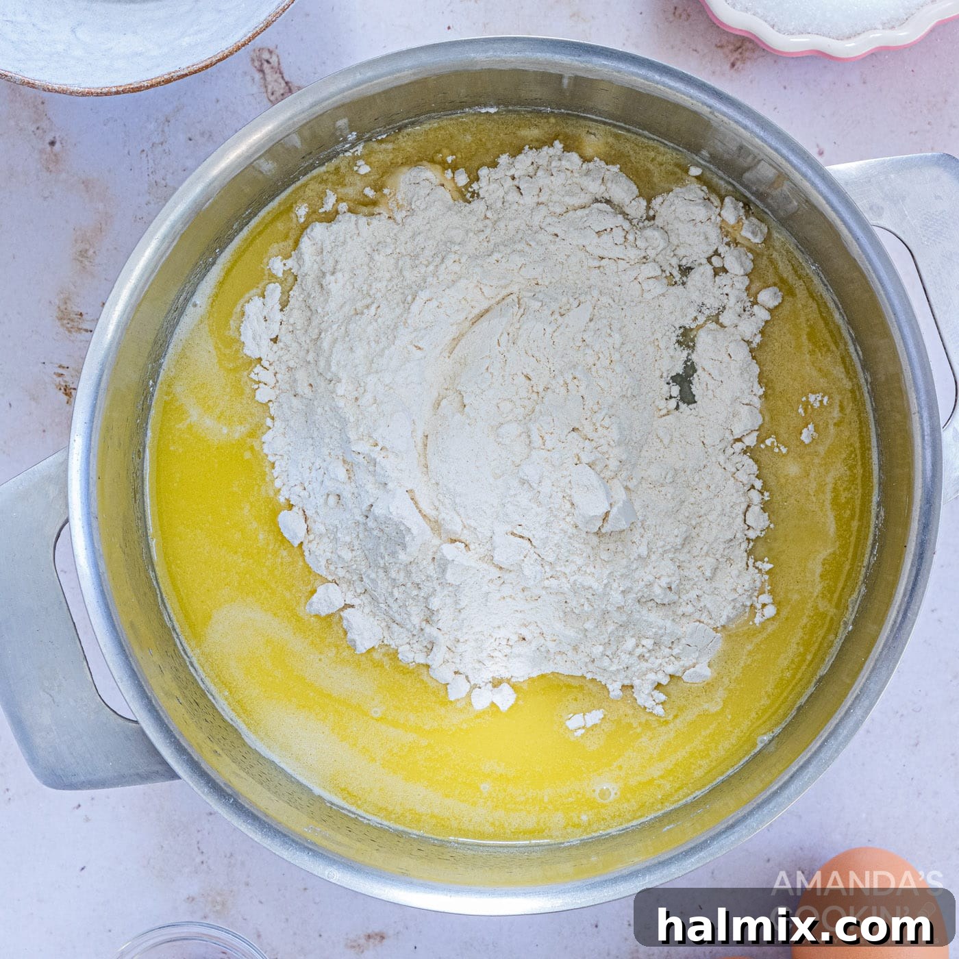 adding flour to water, butter, sugar, and salt