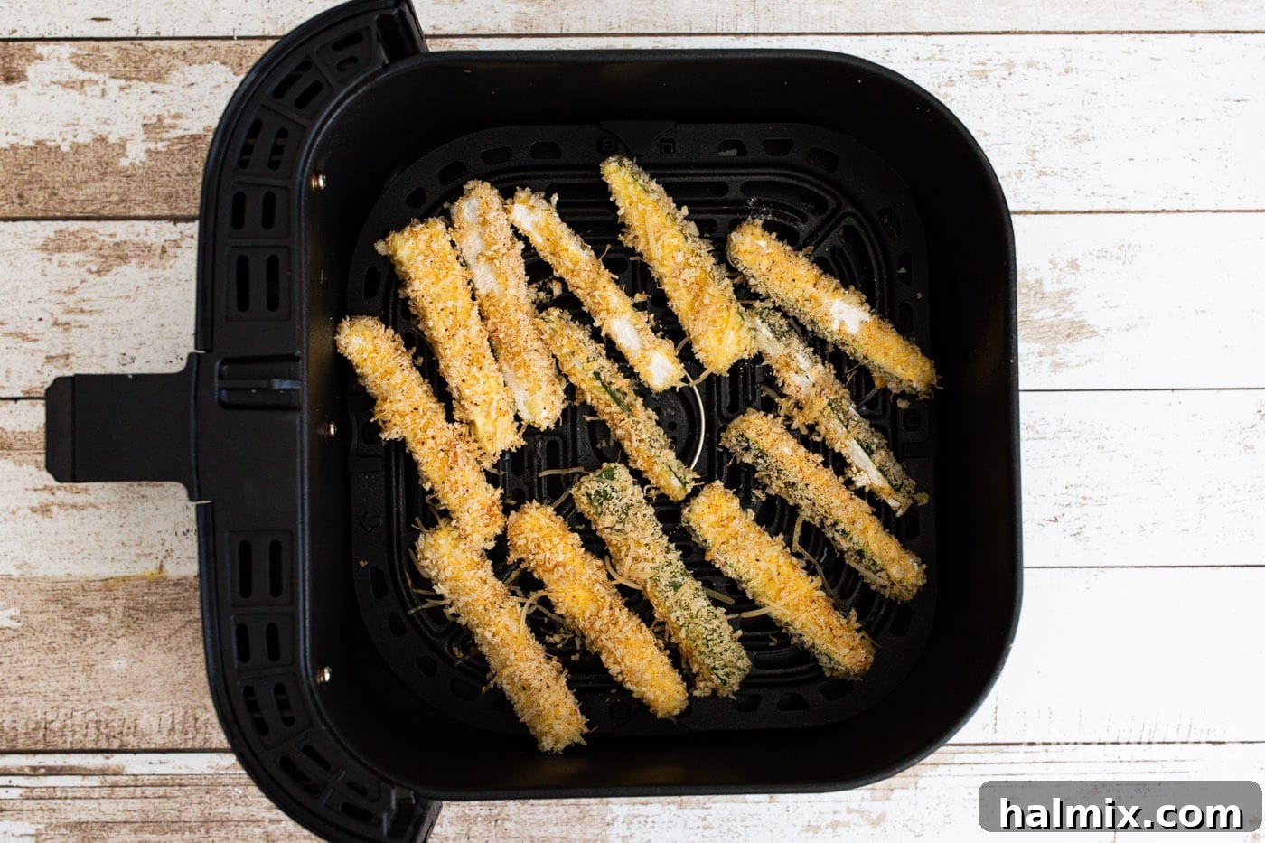 Zucchini fries arranged in a single layer in the air fryer basket