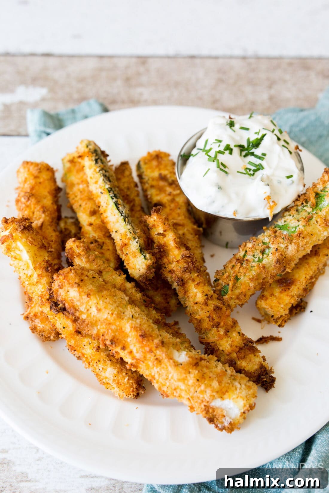 A plate of air fryer zucchini fries served with a creamy dipping sauce