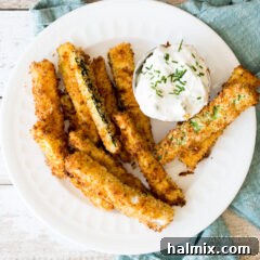 Air fryer zucchini fries with sauce on a plate