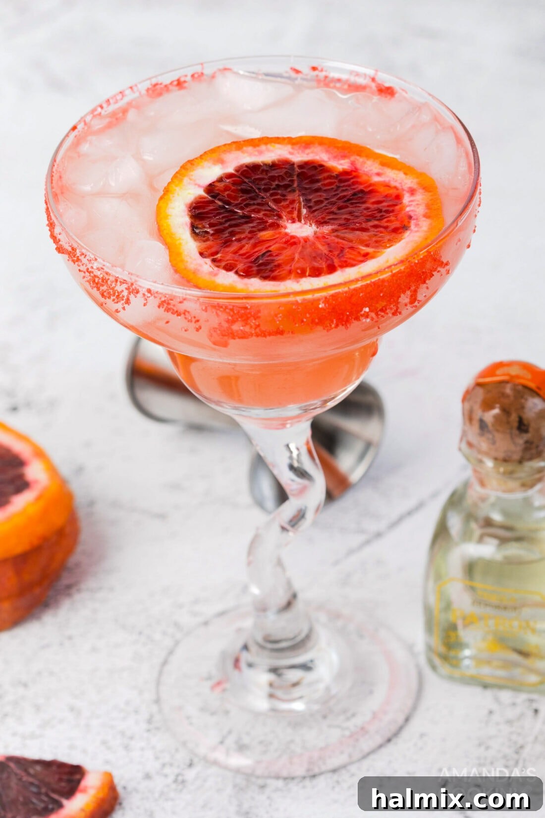 Crimson Sunset Margarita 2 Vibrant blood orange margarita with a sugared rim, garnished with a fresh blood orange slice.