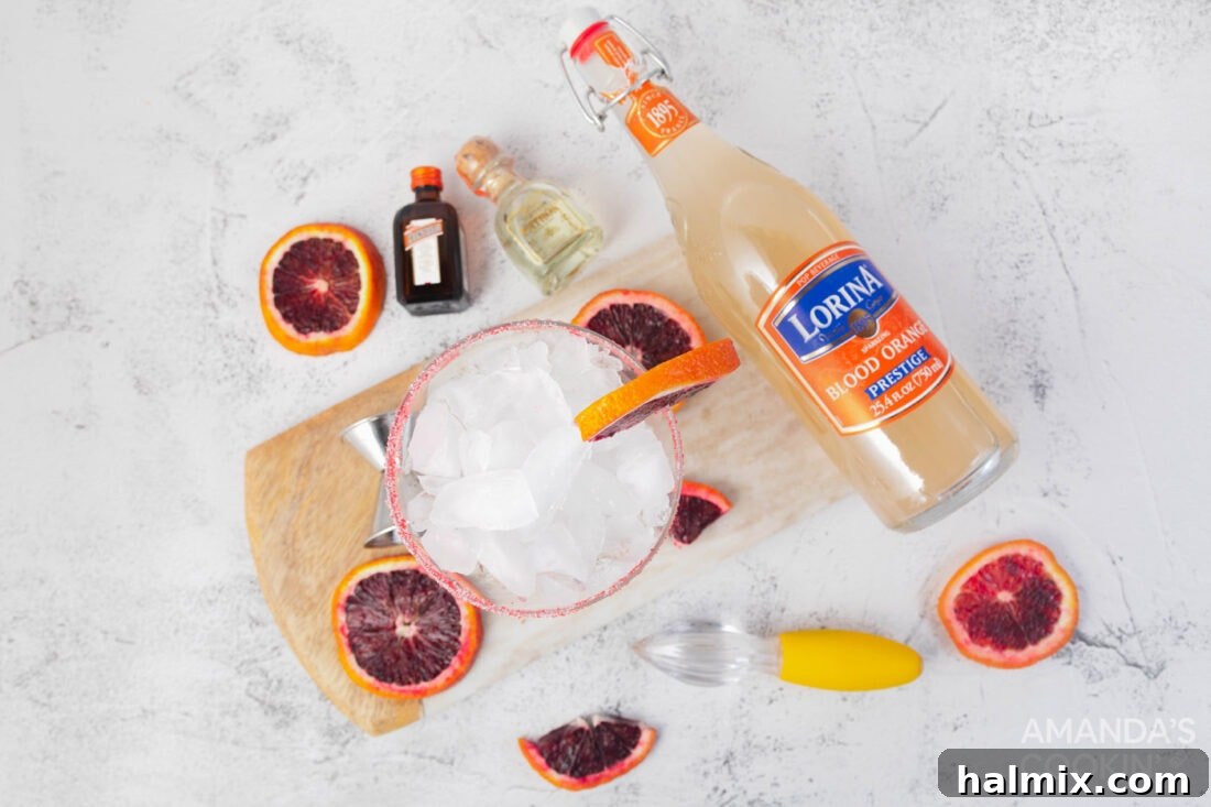 Crimson Sunset Margarita 4 Ingredients for blood orange margarita laid out: blood oranges, tequila, orange liqueur, simple syrup, and red sugar.