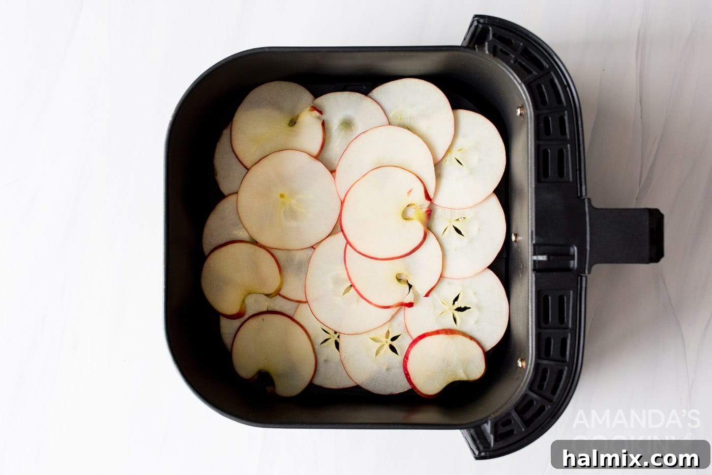 apple slices in an air fryer basket