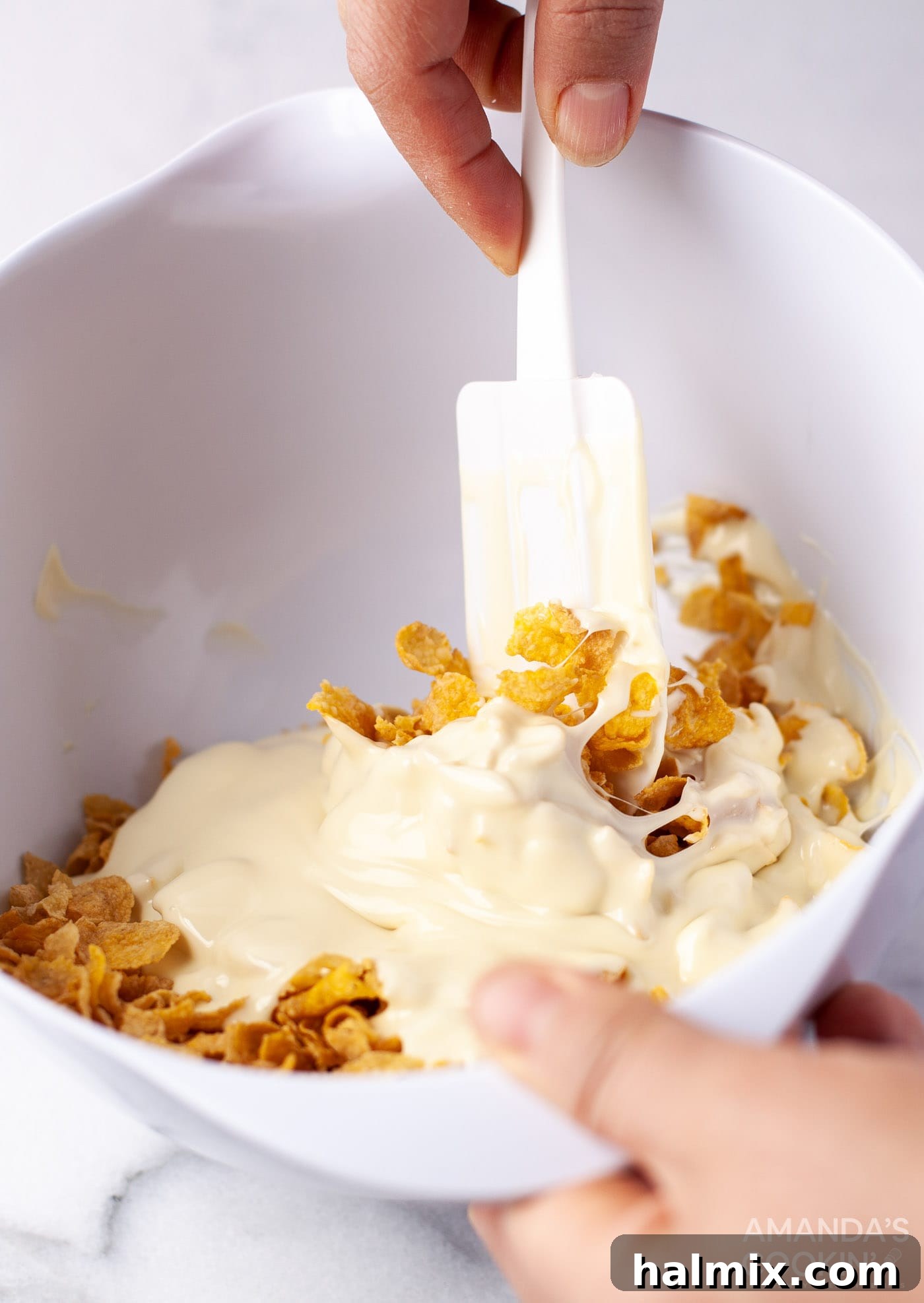 Effortless Cornflake Crunch 8 The process of gently mixing white chocolate with cornflakes for a perfect coating.