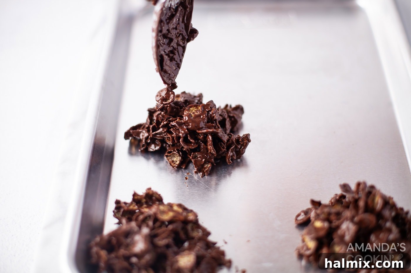 Effortless Cornflake Crunch 10 Carefully spooning the dark chocolate cornflake mixture into uniform cookie shapes on a baking sheet.