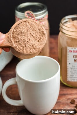 Adding cake mix from the jar into a mug to prepare a single serving.