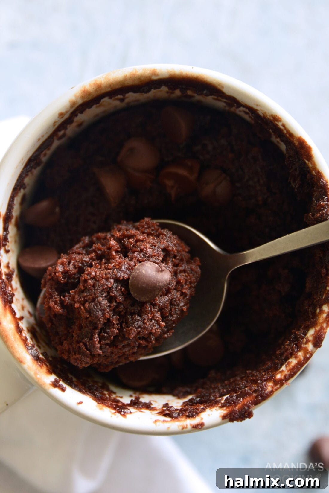 Close-up overhead view of a perfectly baked chocolate mug cake, garnished with chocolate chips.