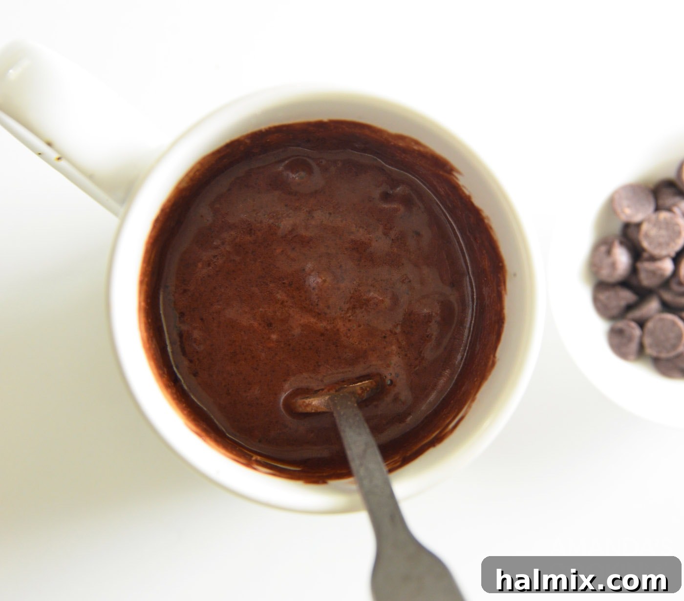 Smooth chocolate cake batter in a mug, ready for the microwave.