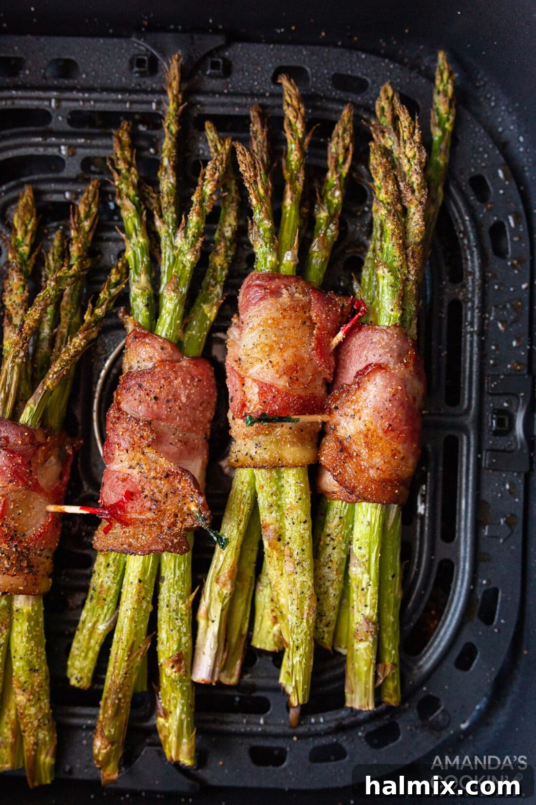 Bacon Wrapped Asparagus bundles neatly arranged in an air fryer basket