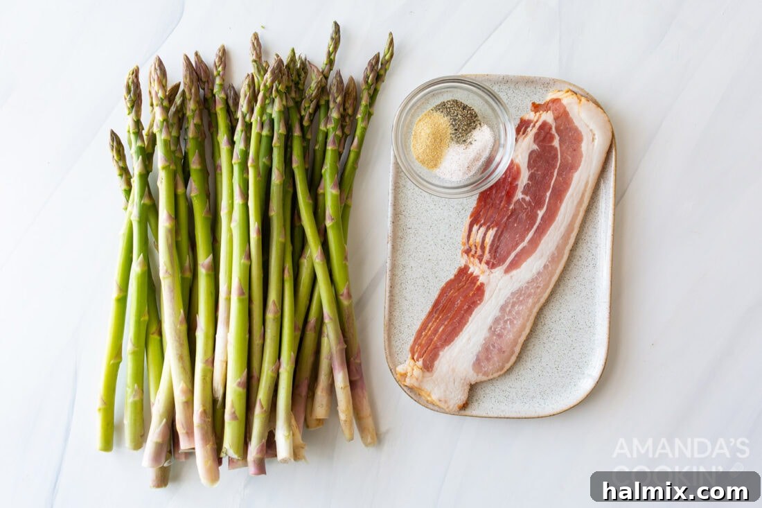 Ingredients laid out for Air Fryer Bacon Wrapped Asparagus including asparagus, bacon, and seasonings