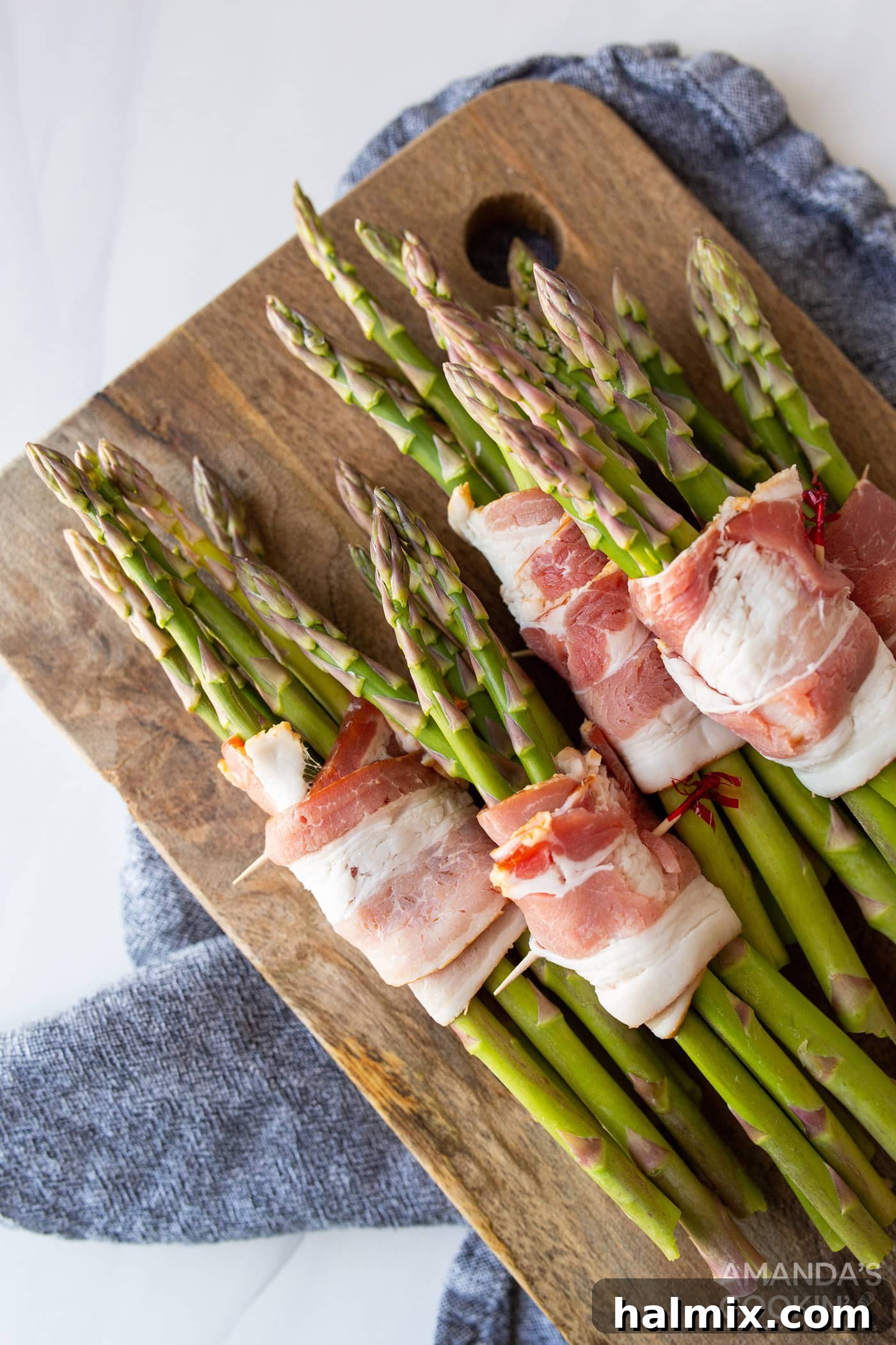 Asparagus bundles securely wrapped in bacon and ready for seasoning