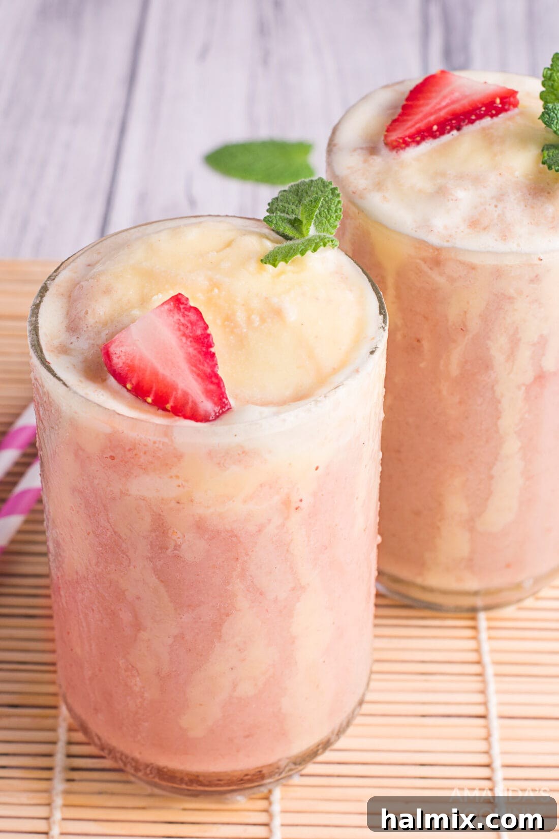 Berry Banana Bubble Bliss 2 Strawberry Banana Fizzy Float - a vibrant red and yellow drink in a tall glass, topped with a scoop of vanilla ice cream.