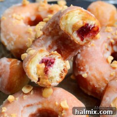 A freshly cut donut showing the layers of dough, peanut butter, and jelly filling.