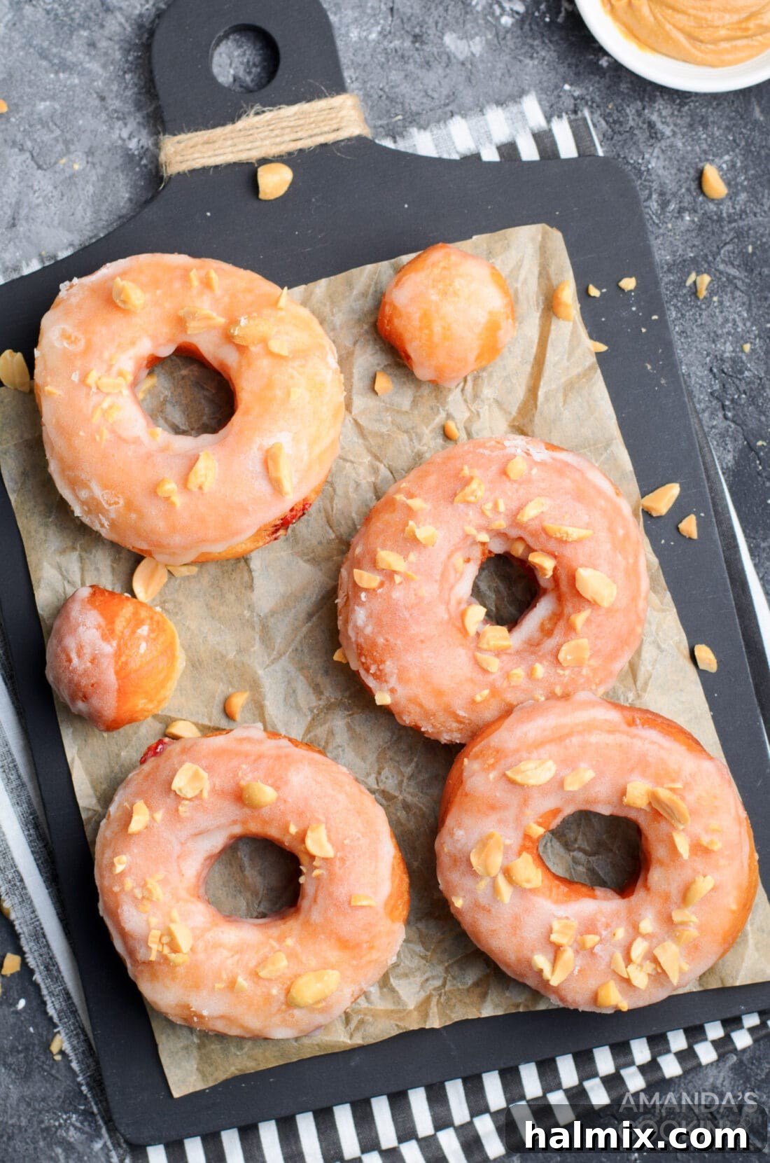 Freshly fried donuts cooling on parchment paper, awaiting their delicious filling.