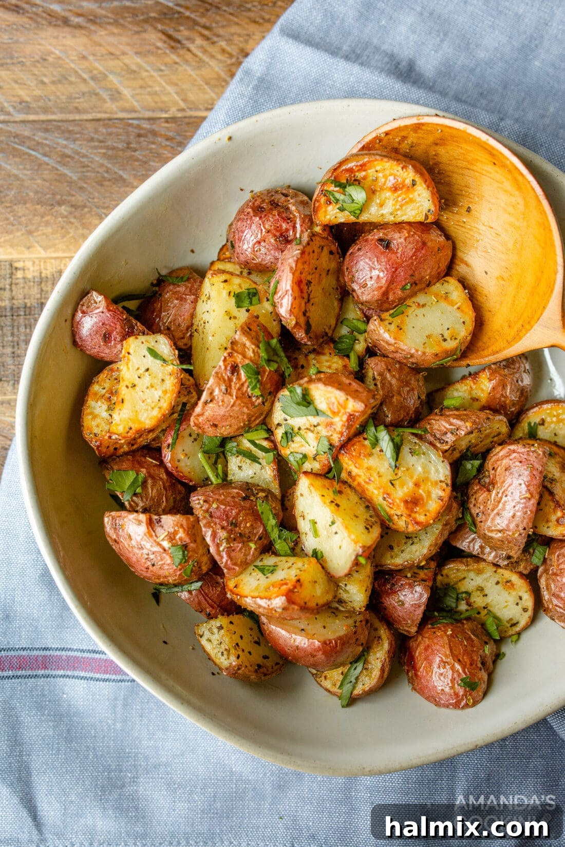 A beautiful bowl of golden-brown crispy air fryer roasted potatoes, garnished with fresh herbs, ready to be served.
