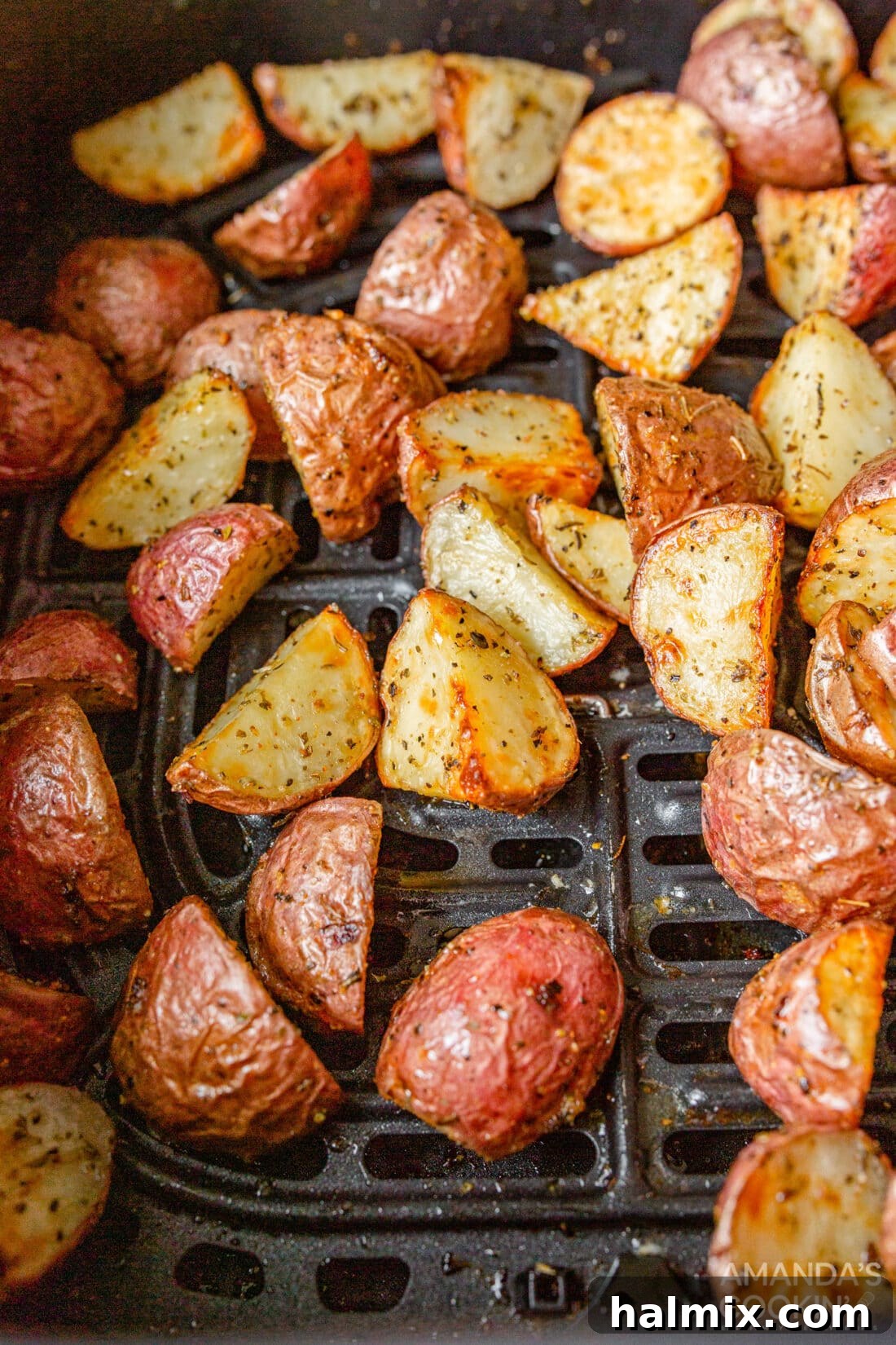 Close-up shot of golden, perfectly roasted potato pieces inside an air fryer basket, showcasing their irresistible crispiness.