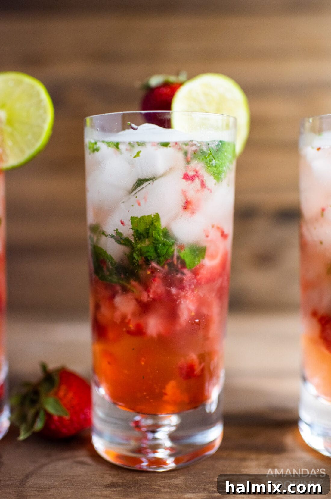 A beautifully garnished glass of Strawberry Mojito with fresh mint and lime slices