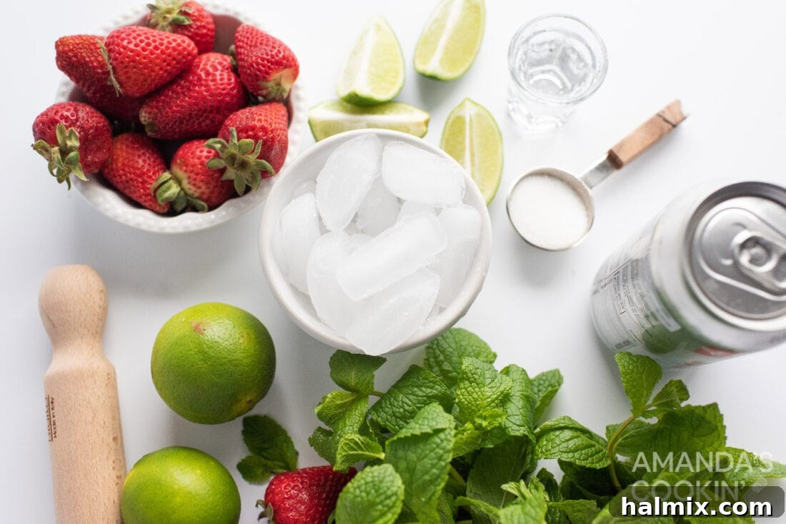 Assortment of fresh ingredients for Strawberry Mojito including strawberries, limes, mint, and sugar