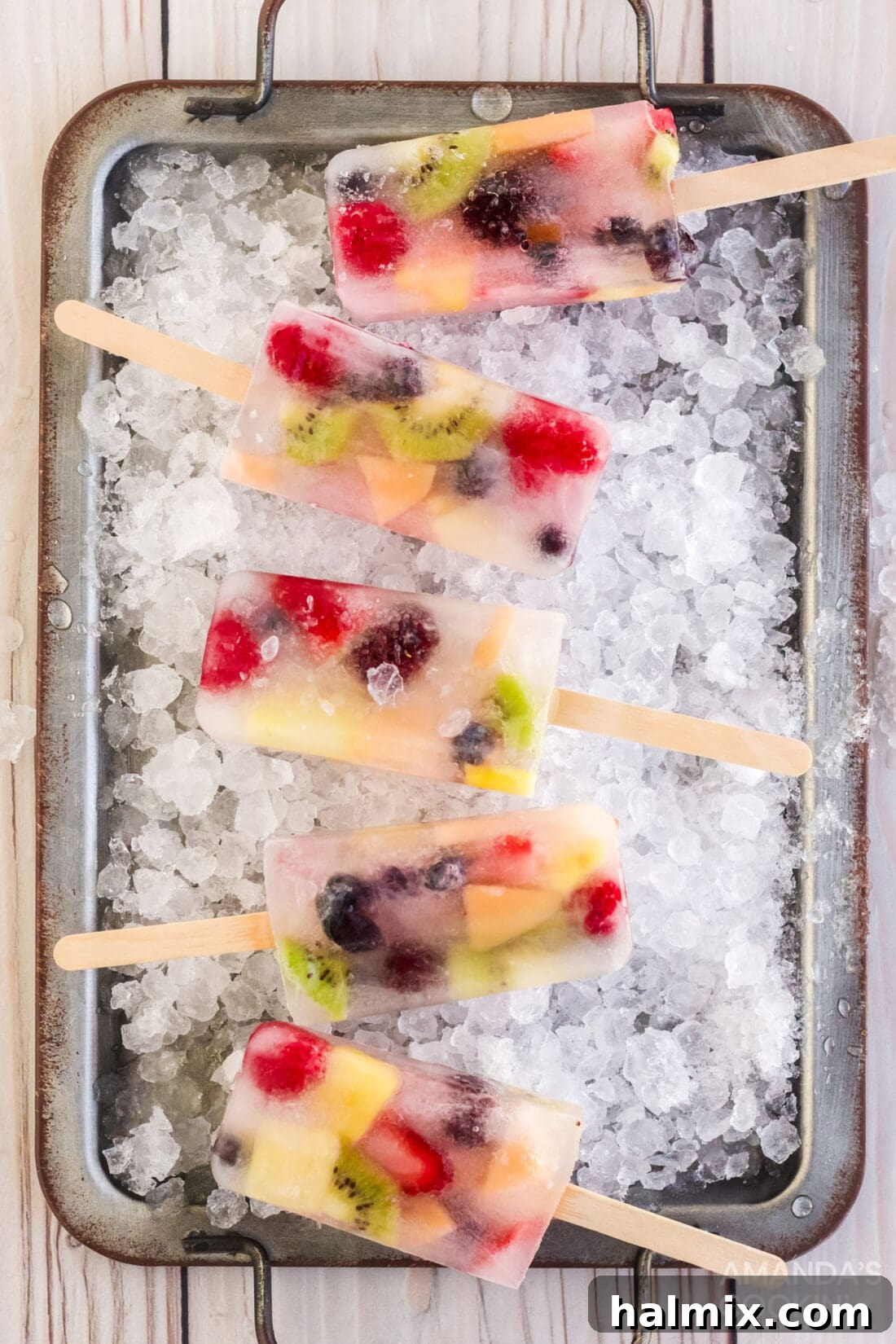 Summer Fruit Delights 3 Assortment of colorful fruit popsicles presented on a bed of ice cubes