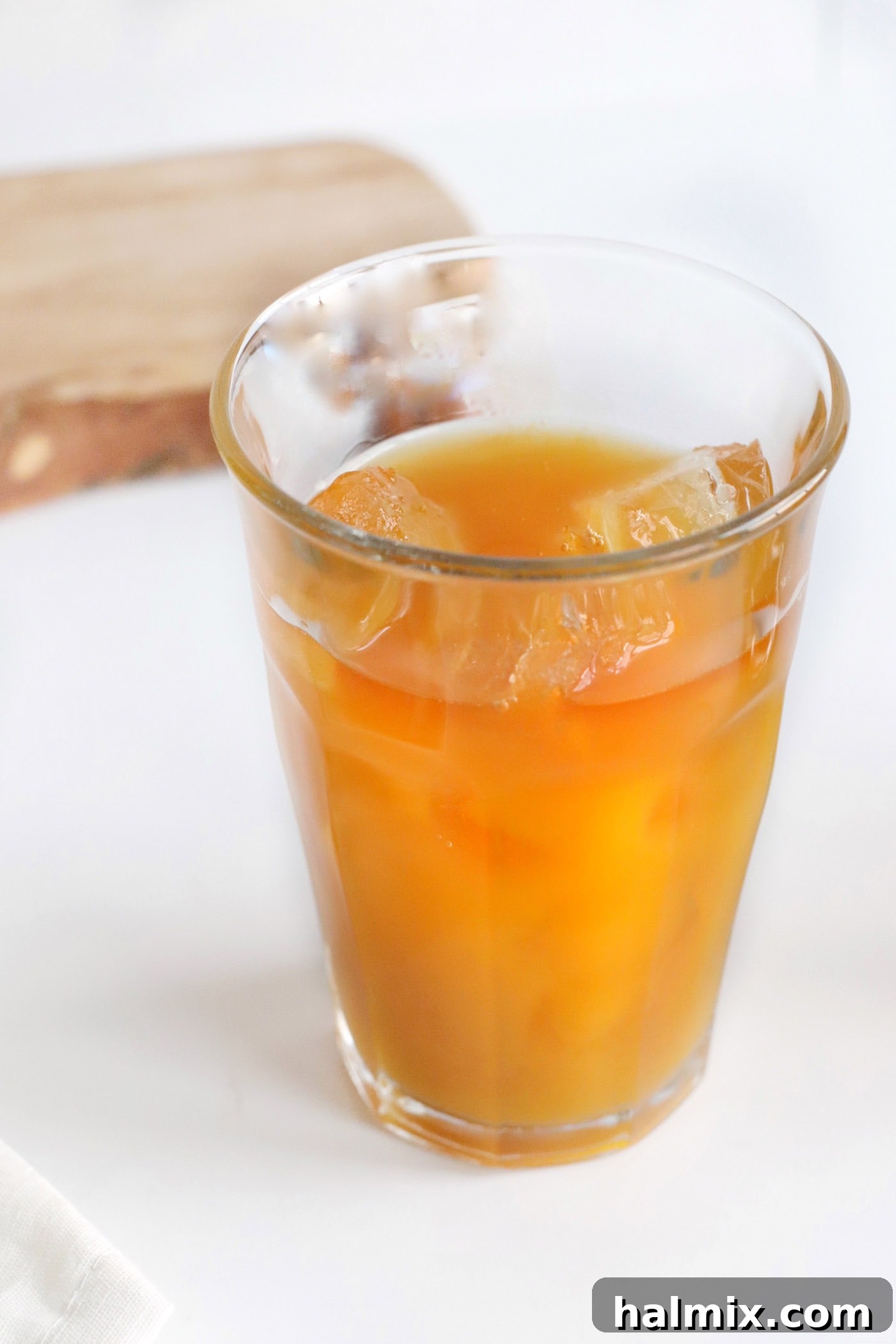 pineapple juice mixed with mango juice and rum in a tall glass, displaying the vibrant, layered effect.