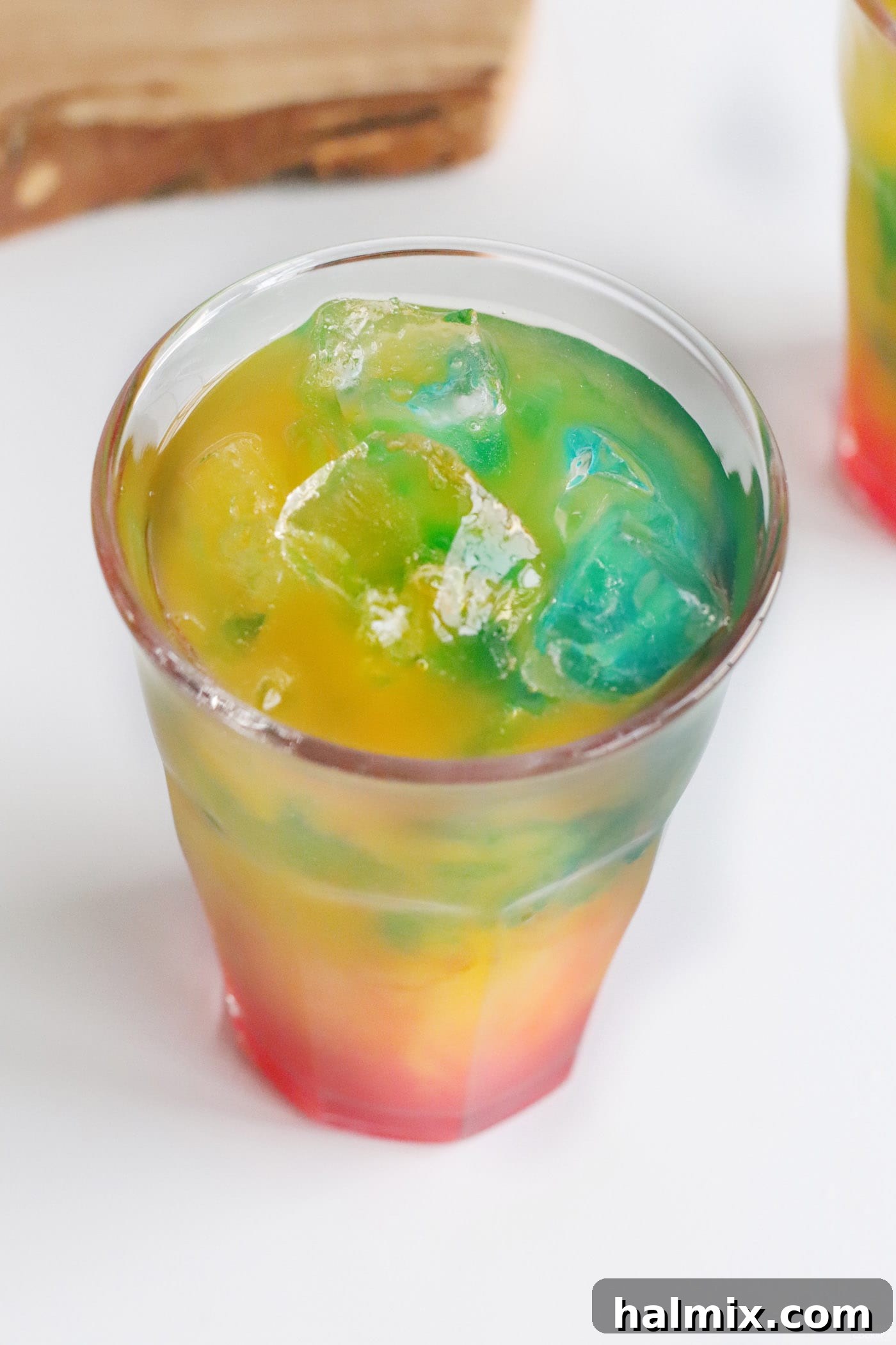 Blue curaçao being added as the final layer to the Blue Hawaiian Mai Tai, creating a striking blue top.