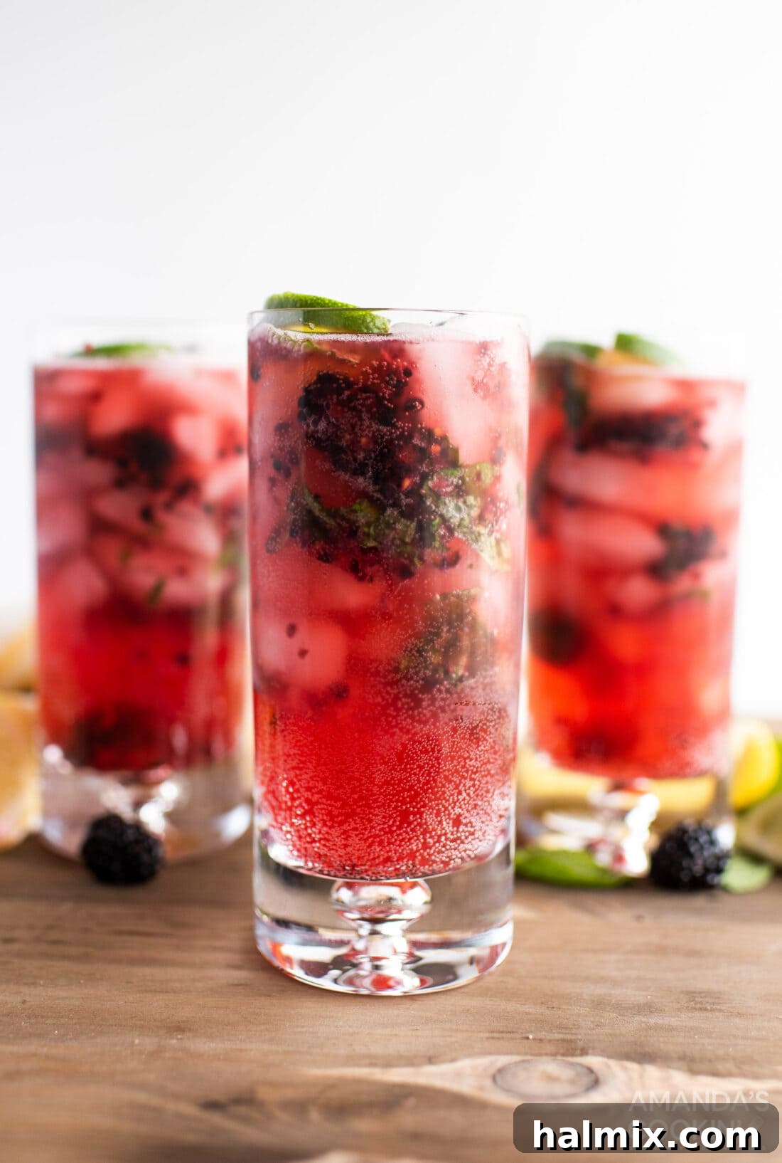 Midnight Mojito 2 Three beautiful glasses of Blackberry Mojito garnished with fresh blackberries, lime slices, and mint leaves, perfectly chilled and ready to be enjoyed on a bright summer day.