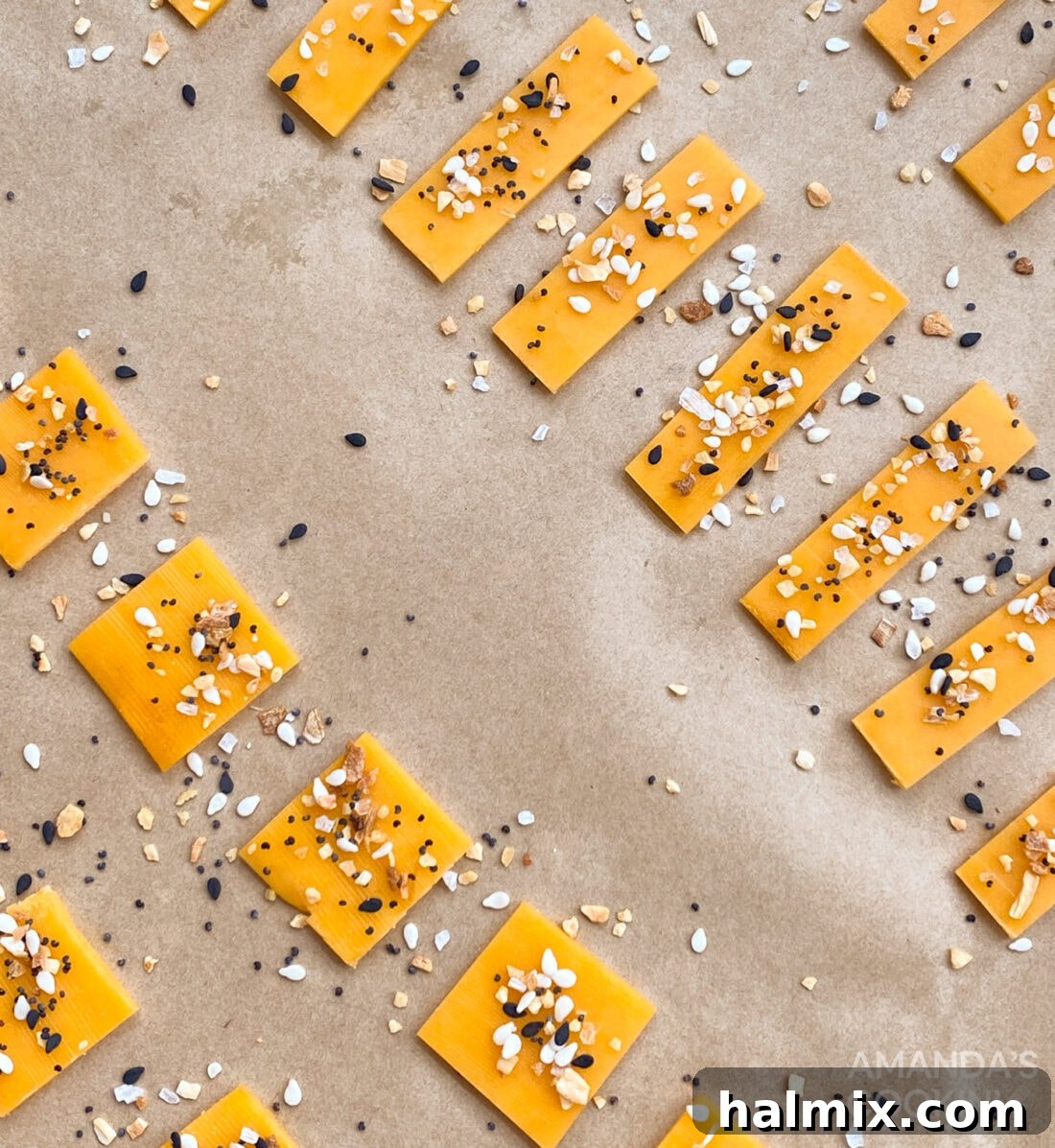 Slices of cheddar cheese neatly arranged, ready for seasoning and baking into keto crackers.