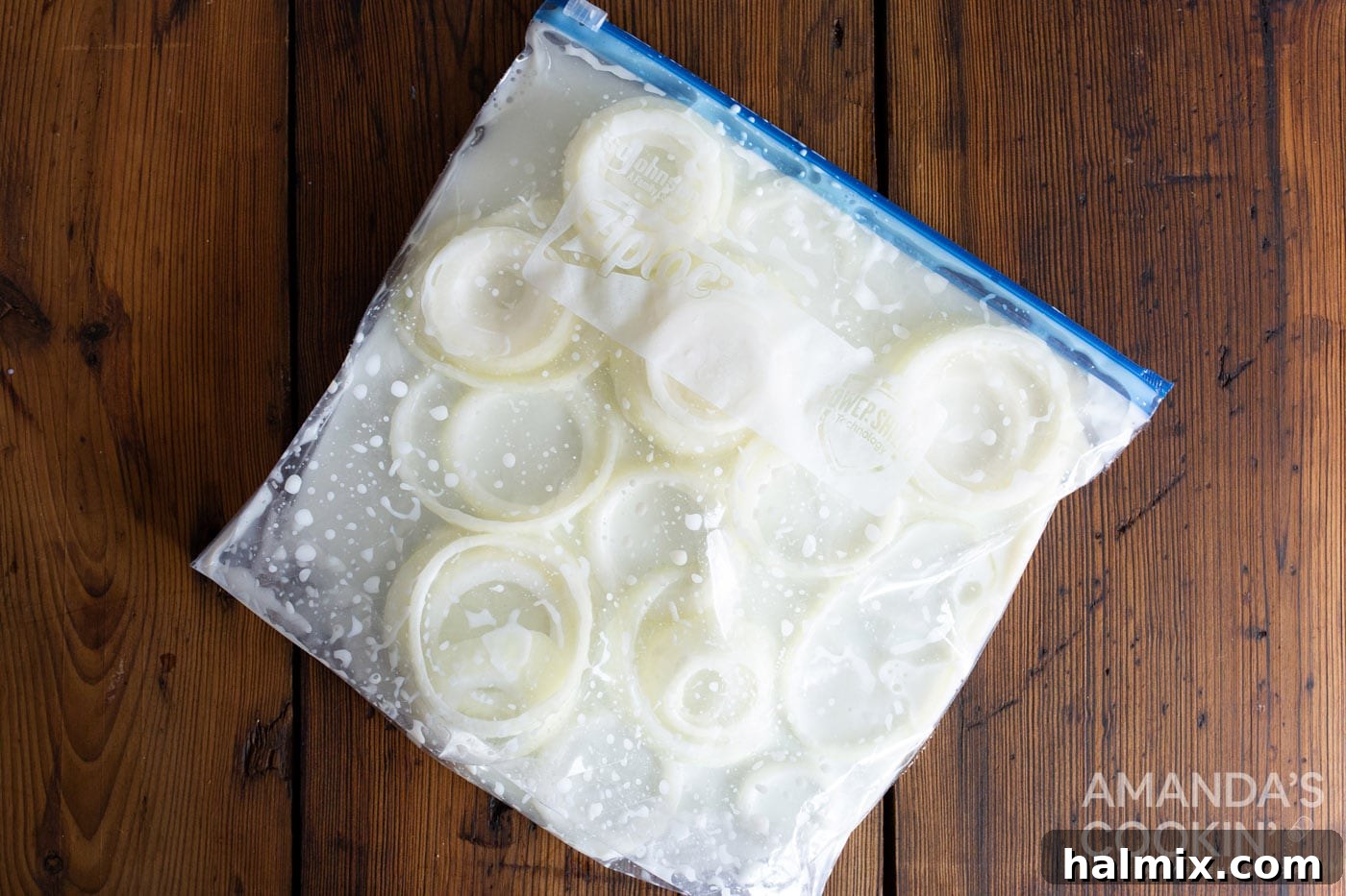 Golden Air-Fried Onion Rings 5 Sliced onion rings soaking in buttermilk inside a Ziploc bag.