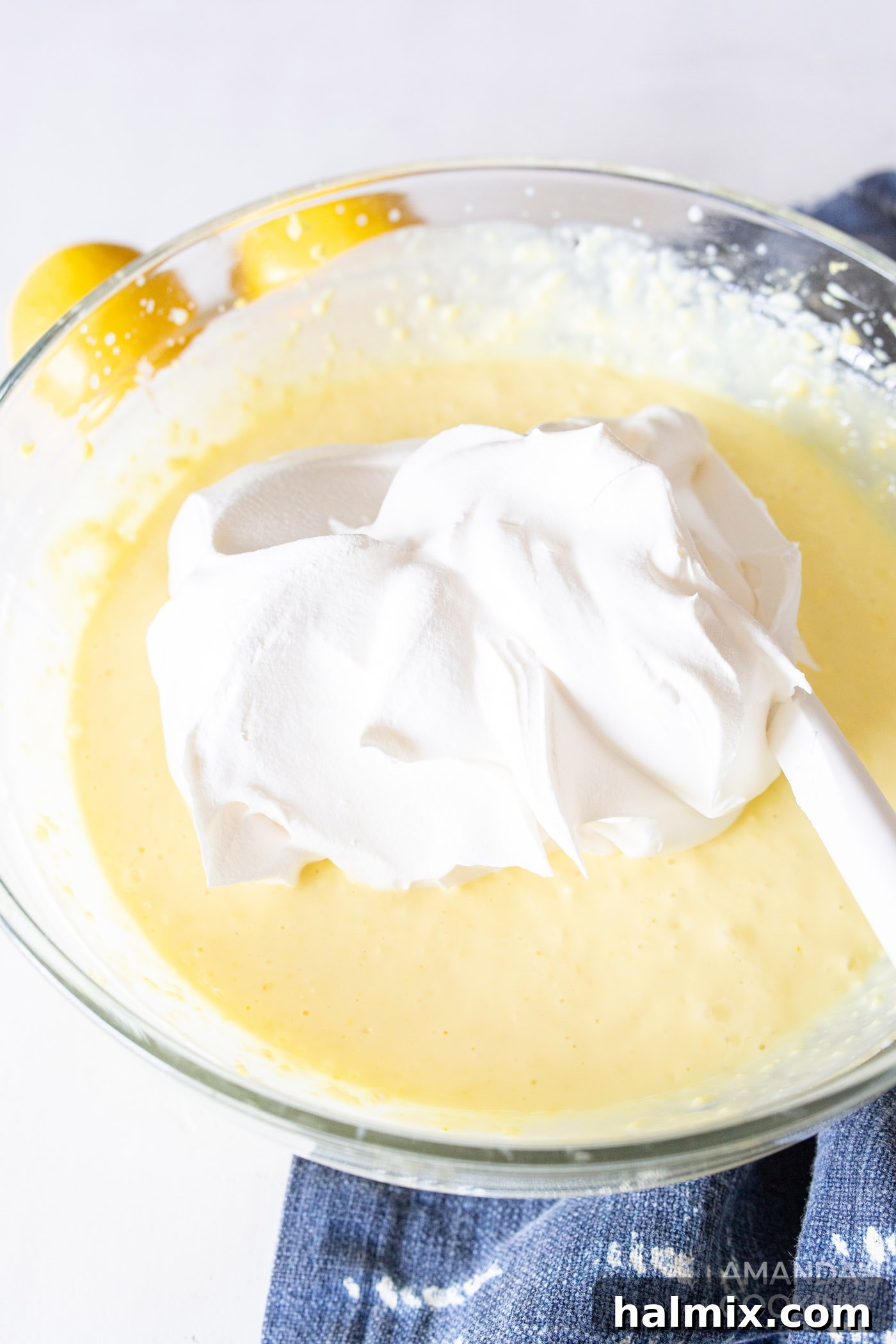 Refreshing Lemon Icebox Cake 8 cool whip gently folded into the bowl of lemon pudding mixture