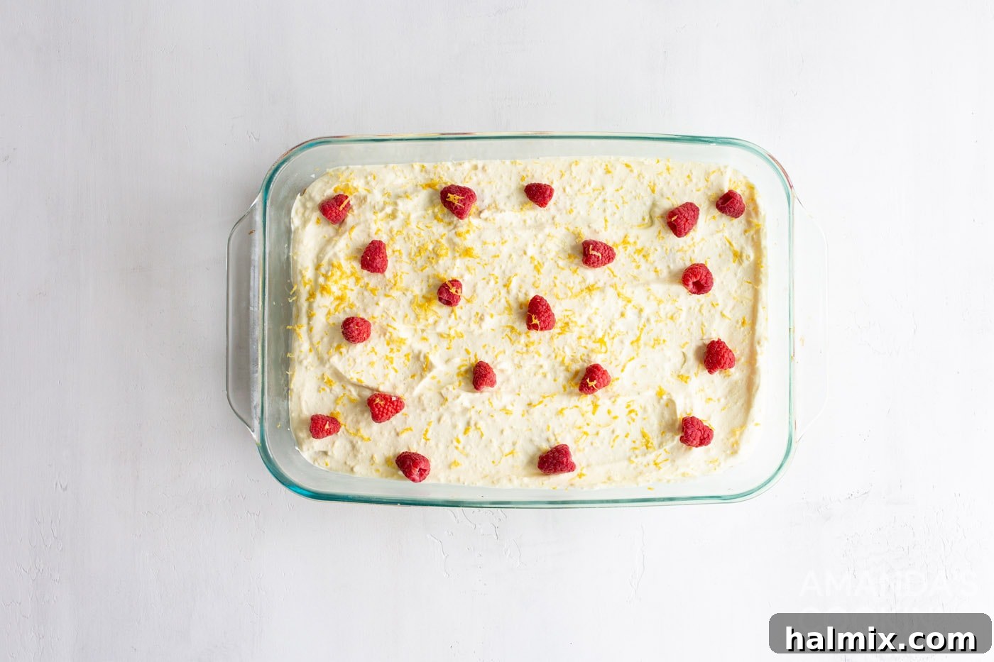 Refreshing Lemon Icebox Cake 10 overhead shot of a finished lemon icebox cake garnished with raspberries and lemon zest