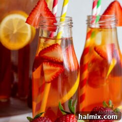 Strawberry sweet tea in a glass, garnished with fresh berries and lemon