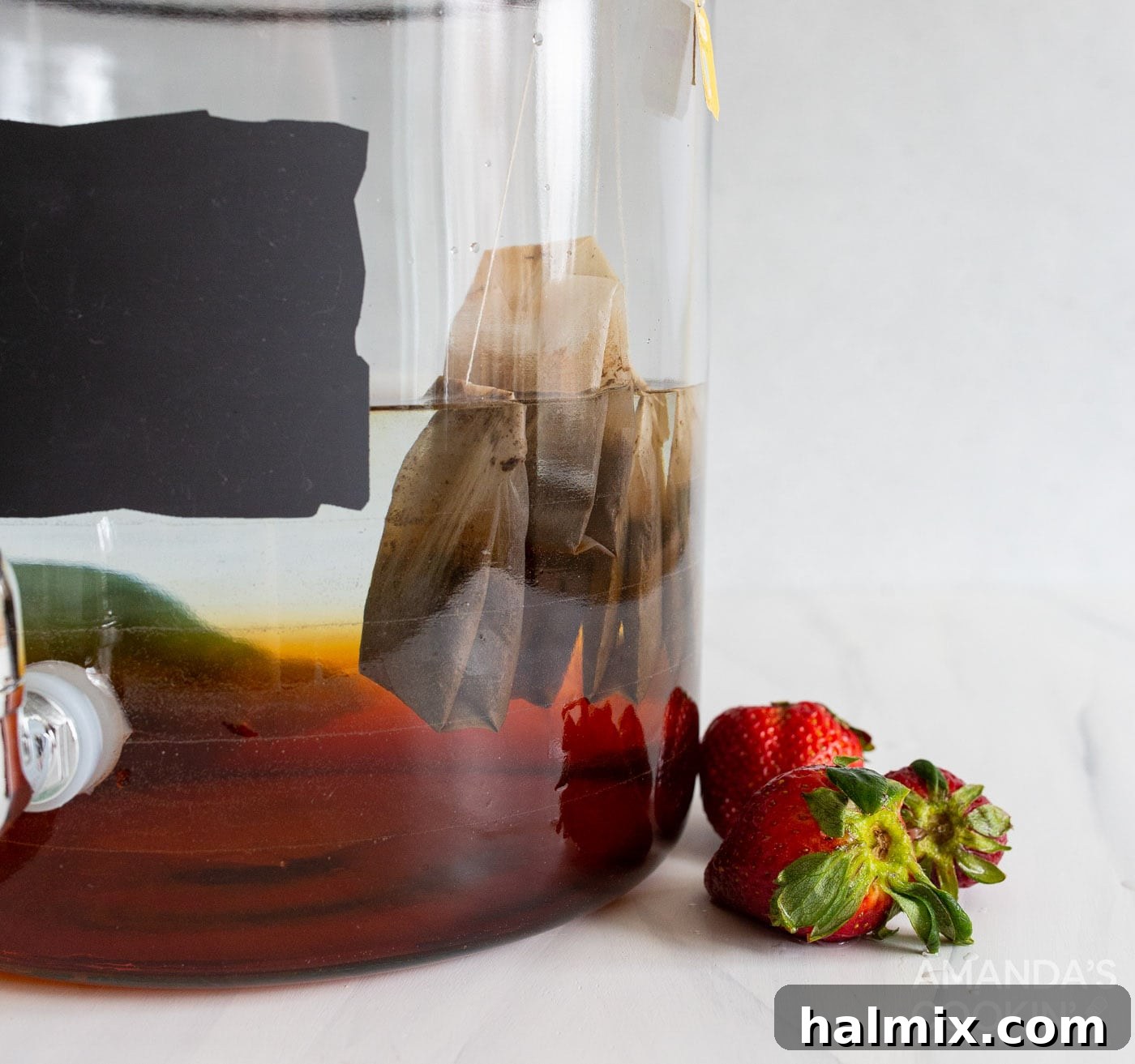 Tea bags with tags secured to the side of a pitcher, steeping in water