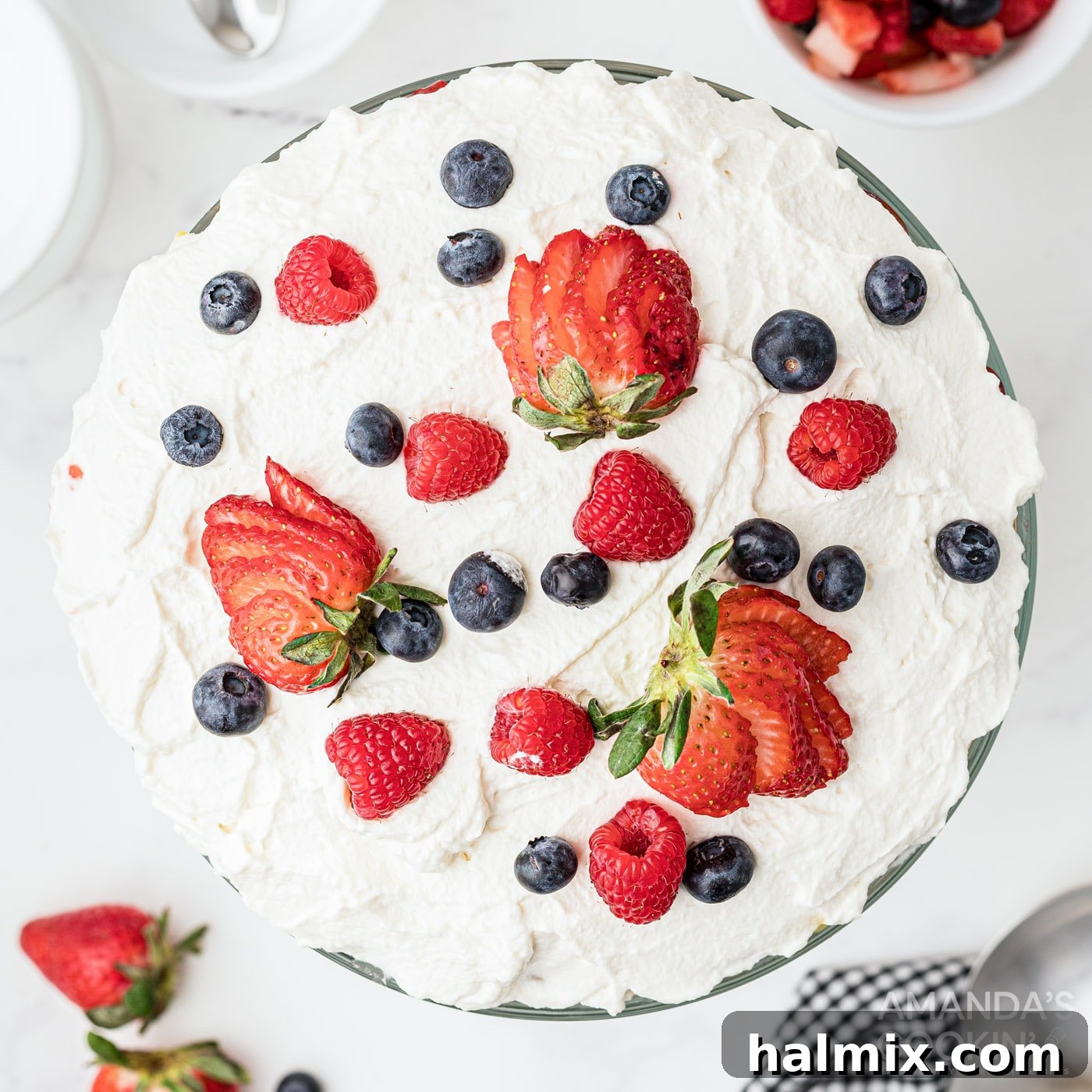 Whipped cream and berries on top of a finished Jello Trifle