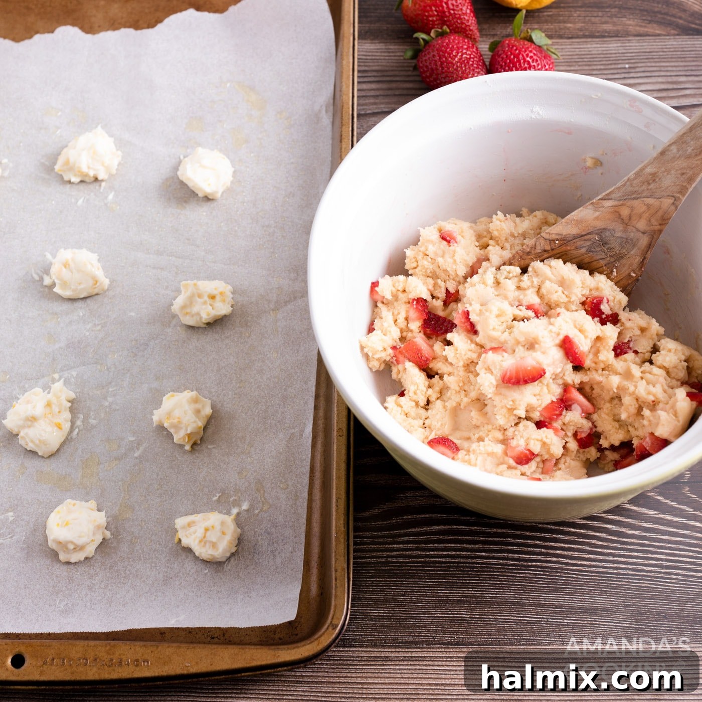 cream cheese balls on baking sheet next to bowl of strawberry cookie dough