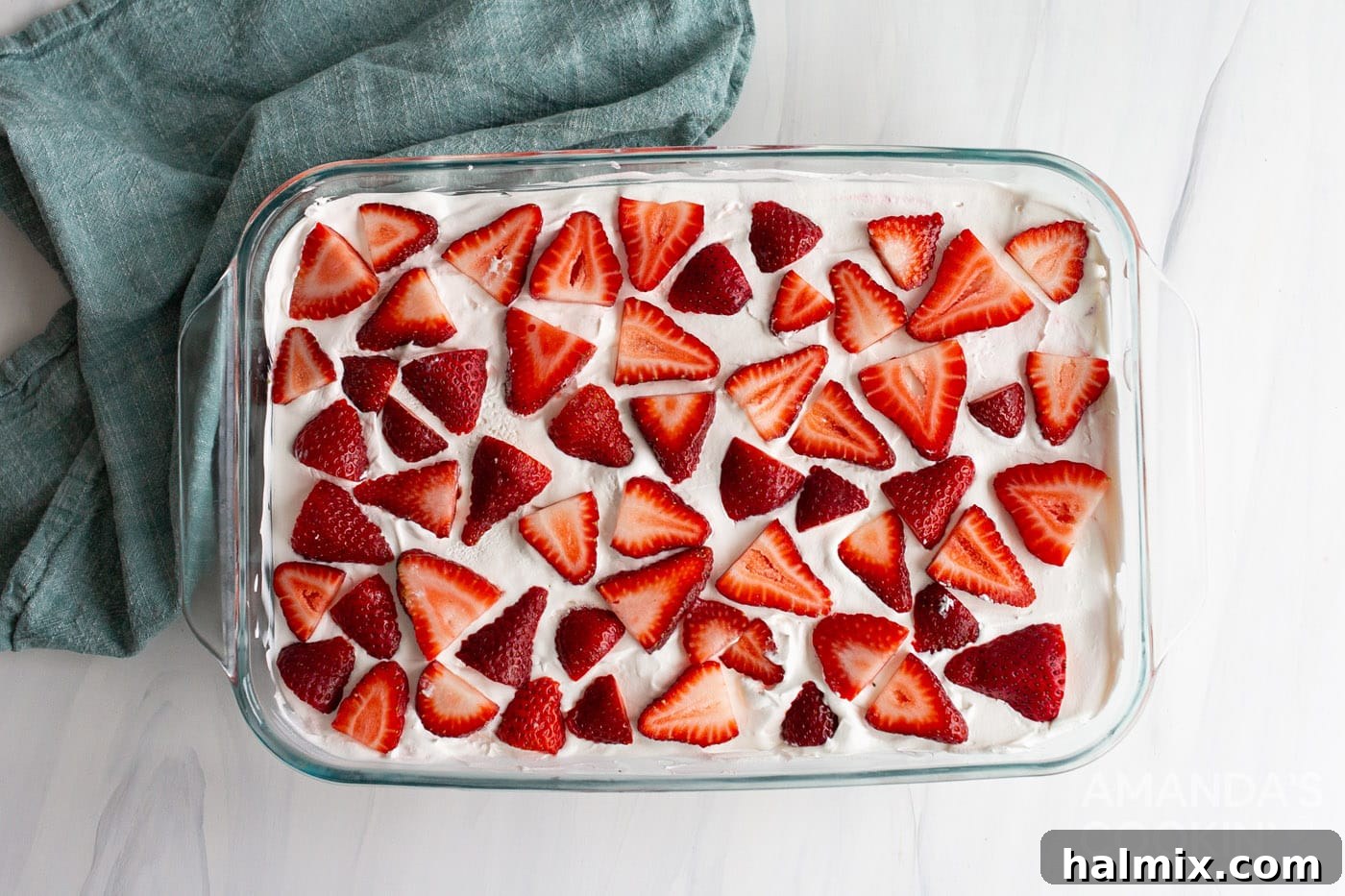 Sliced fresh strawberries arranged on top of the finished layered dessert in a baking dish