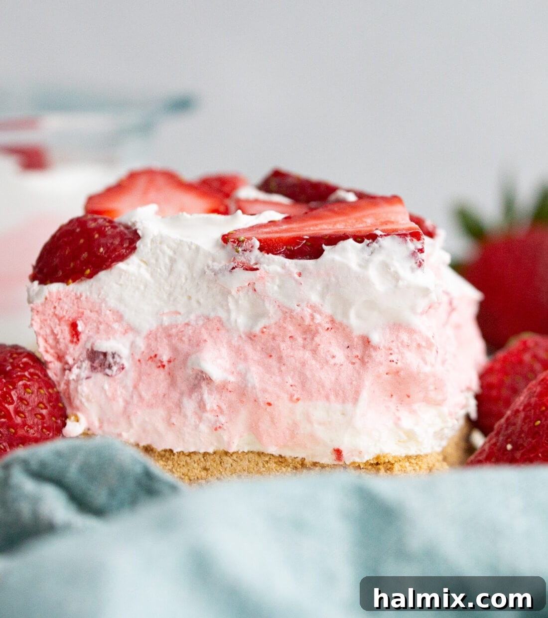 A perfectly square slice of Strawberry Lasagna, showcasing its distinct, colorful layers.