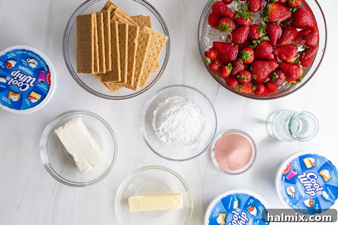 All the fresh ingredients laid out for making Strawberry Lasagna, including graham crackers, butter, cream cheese, powdered sugar, cool whip, strawberry jello mix, and fresh strawberries.