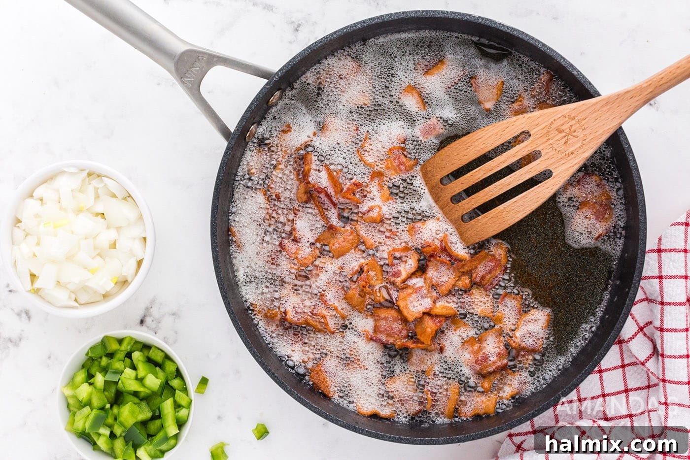 Bacon pieces sizzling in a hot skillet, becoming crispy