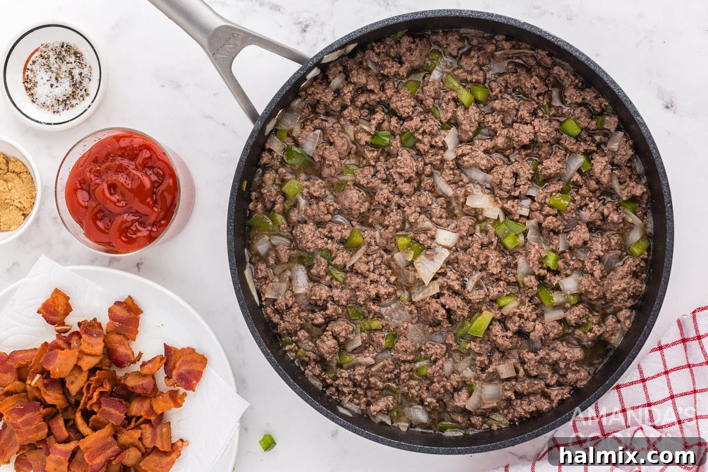 Ground beef, onions, and bell peppers cooking in a skillet