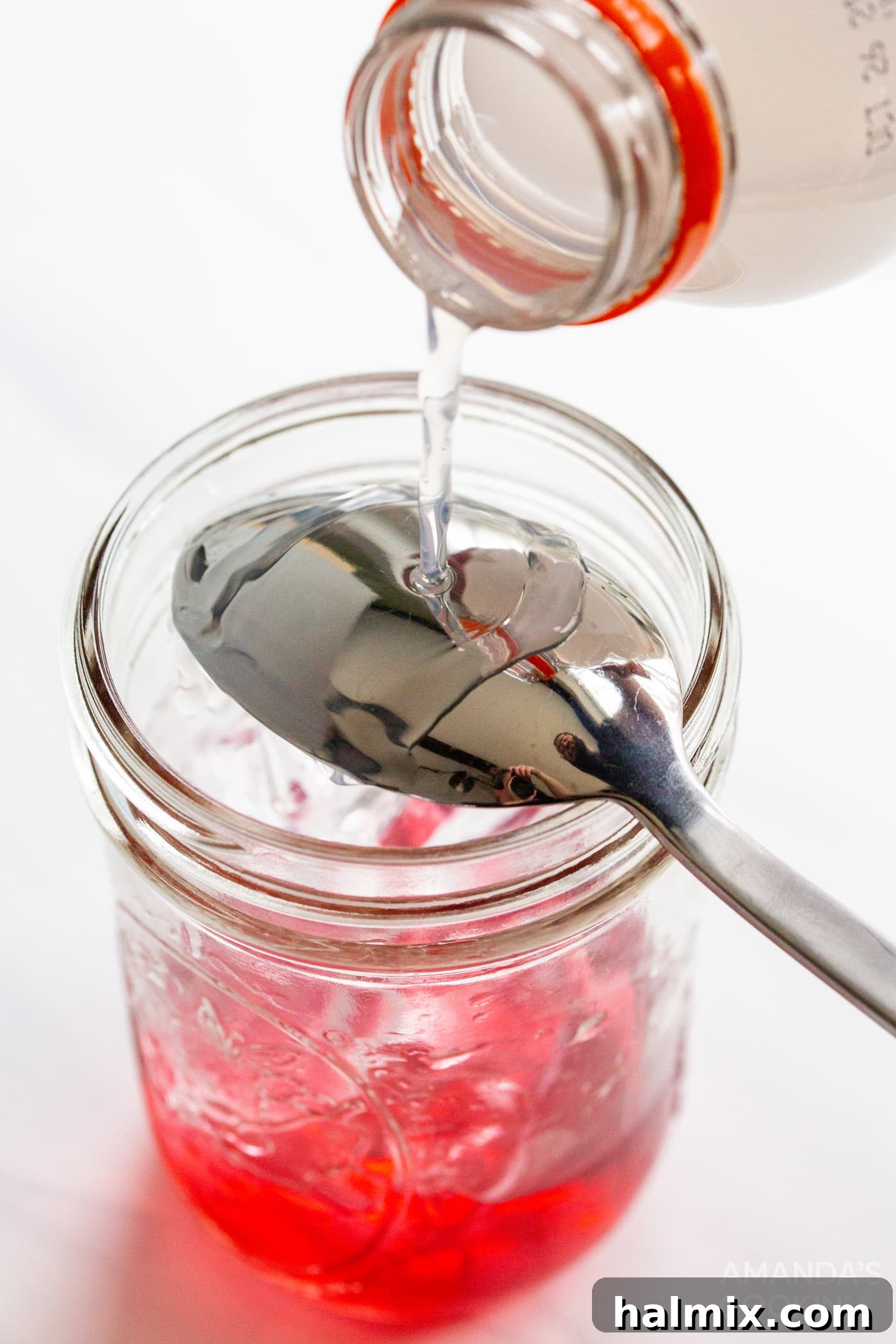 Pouring white Gatorade Frost over the back of an upside-down spoon onto the ice